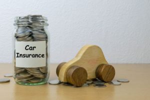 toy car next to a jar filled with coins labelled "car insurance"