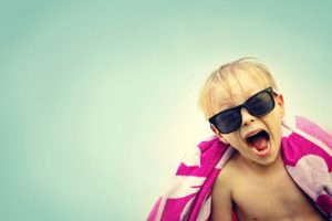 kid with sunglasses, wrapped in towel